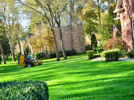 picture of a lawn mowing service professional mowing a lawn with a xero turn mower